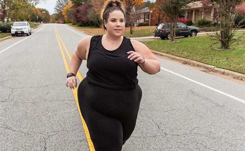 Whitney is running down the street during a workout