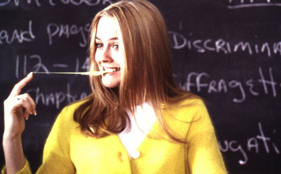 Still from Alicia Silverstone in Clueless playing with her chewing gum when being asked in the class to come to the front.