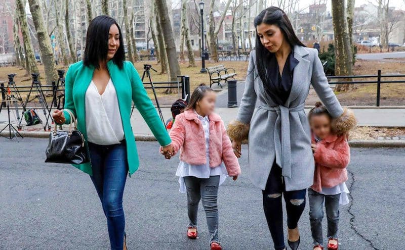 Emali and Maria Joaquina are walking with their mother and a friend in a city park.