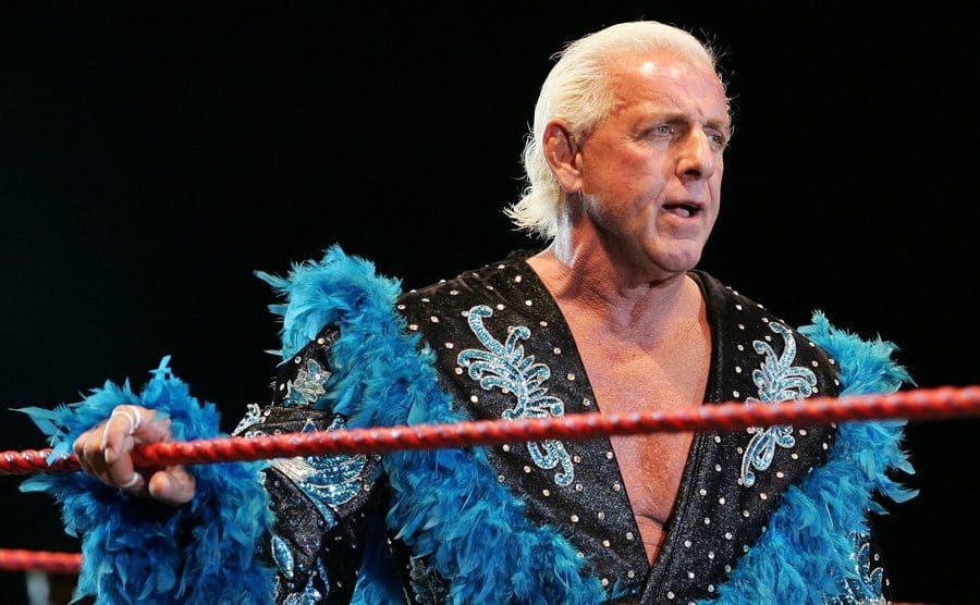 Ric Flair, dressed on black velvet and blue feathers, looks on while awaiting the entrance of Hulk Hogan.