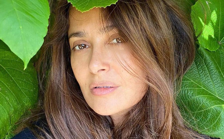 Salma Hayek takes a selfie surrounded by leaves.
