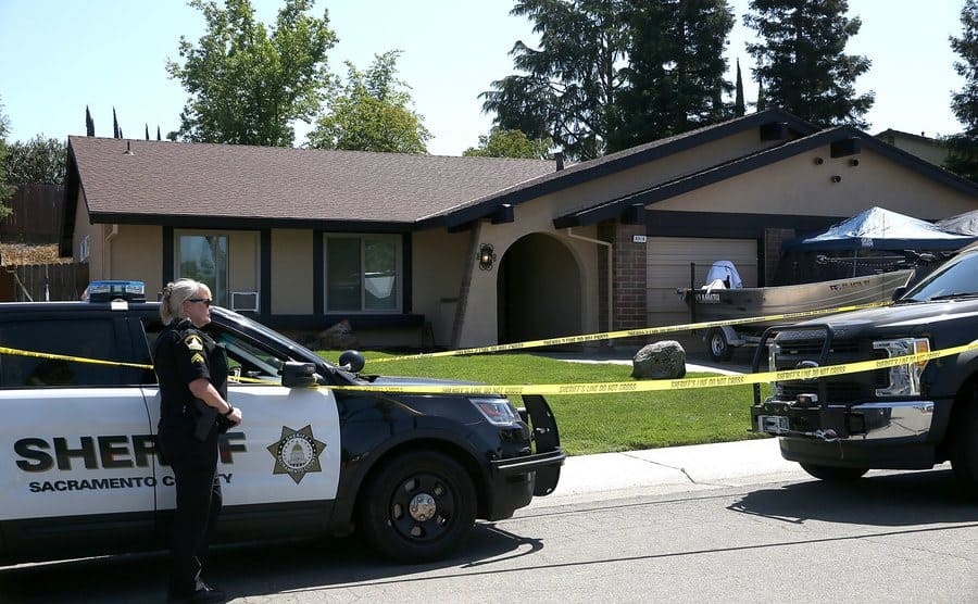 A Sacramento County sheriff deputy stands guard in front of the home of accused rapist and killer Joseph James DeAngelo.