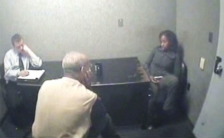 Norwood speaks to two detectives in an interrogation room.