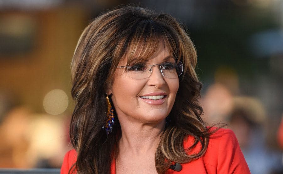 Close-up on Sarah Palin sitting live onstage. 