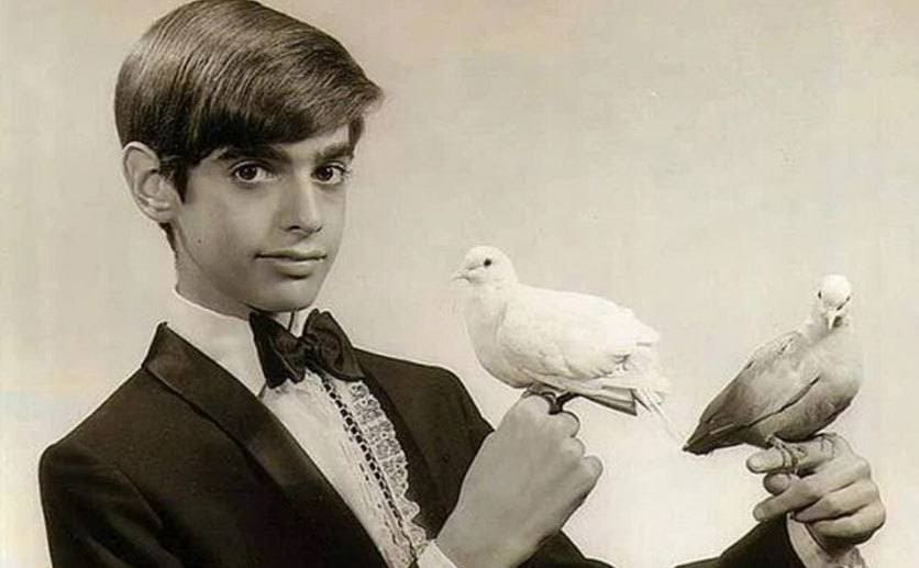 Young child David is doing a magic trick with two doves. 