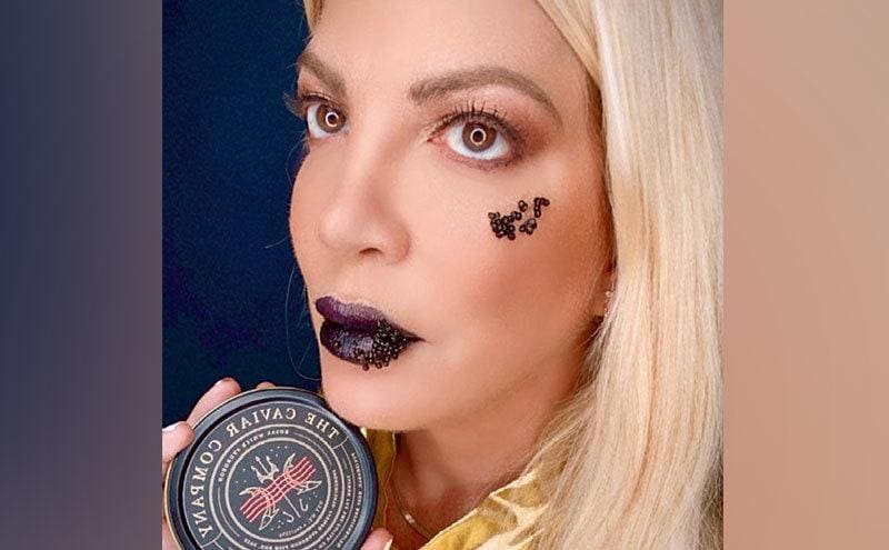 Tori spelling decorates her face with black caviar.
