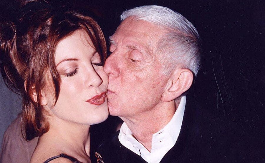 Tori Spelling gets a kiss from her father on the cheek. 