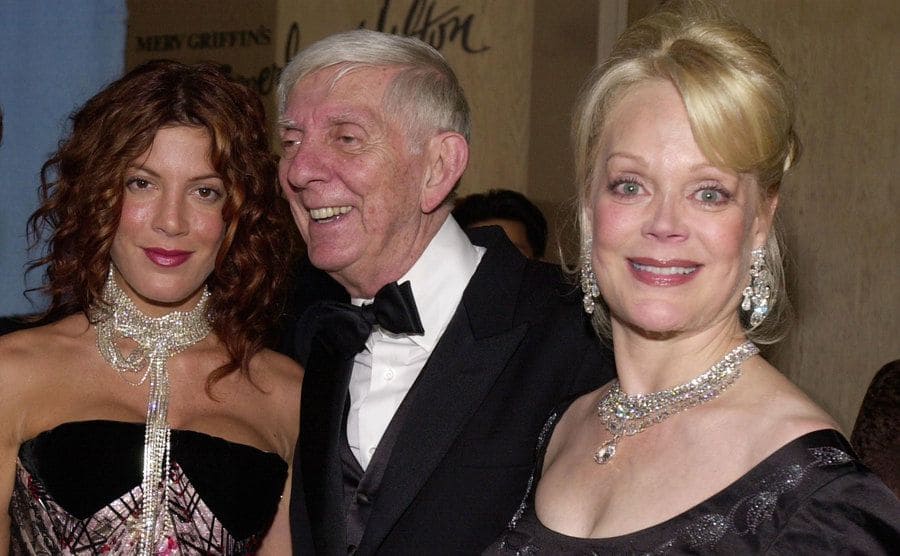 Tori Spelling, Aaron Spelling, and Candy Spelling are posing at an event. 