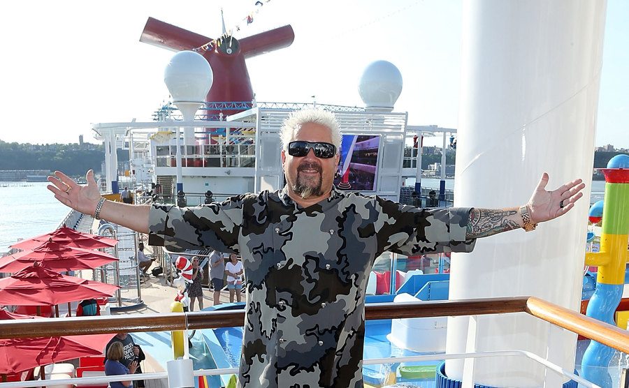 Guy Fieri poses on a cruise ship. 