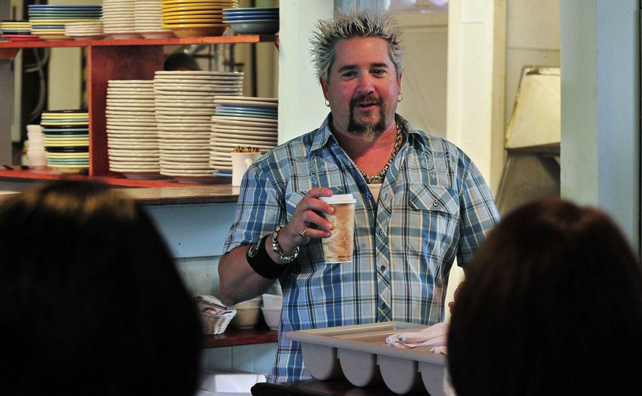 Guy Fieri stands in the kitchen during filming. 