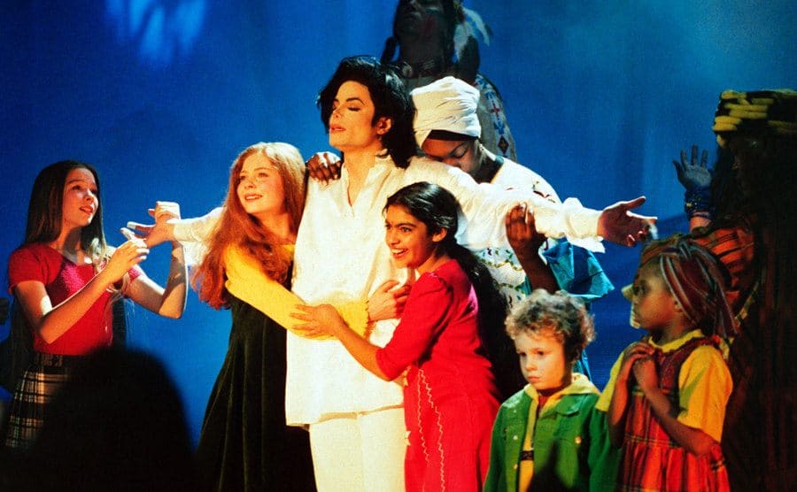 Michael Jackson performs onstage with children. 