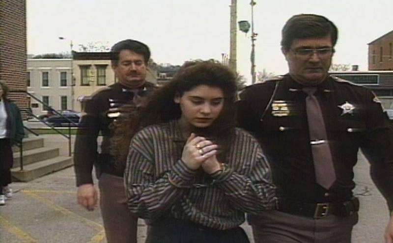 Police officers escort Melinda to court. 
