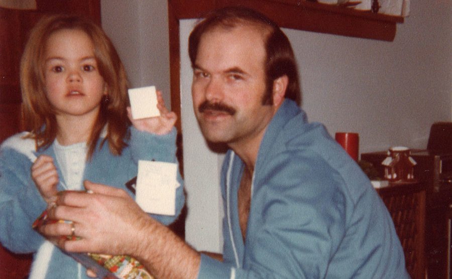 Dennis Rader opens presents with his daughter on Christmas morning. 