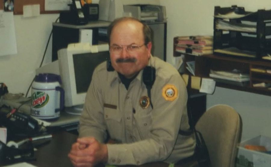 Rader is in his office at his job as a security guard. 