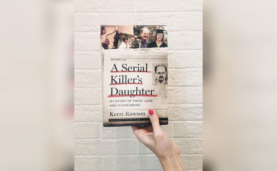 A woman's hand holds up a copy of Kerri’s book. 