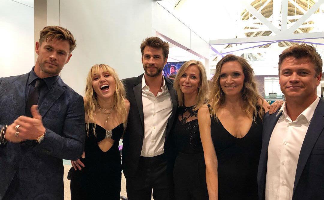 The Hemsworth brothers pose with their partners and mother.