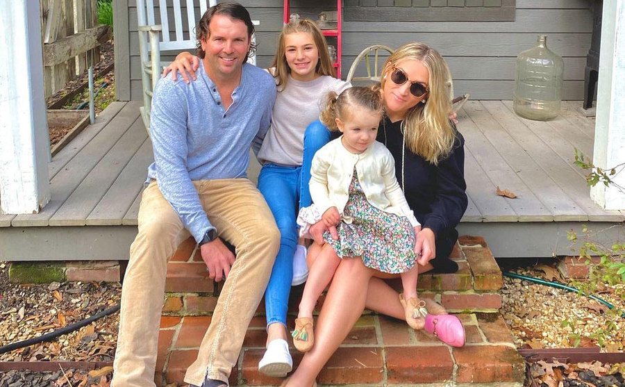 Jamie Lynn poses with her husband and daughters on their front porch. 