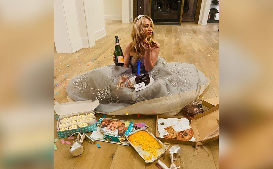 Cuoco sits on her floor in a gown while eating comfort foods. 