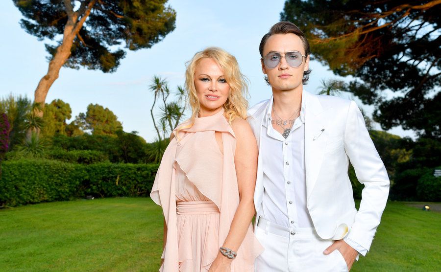 Pamela Anderson und Brandon Thomas Lee posieren in einem Garten bei der Cannes-Gala 2019 