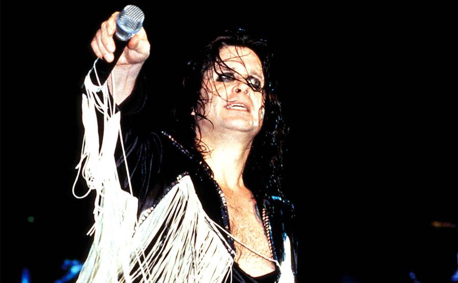 Ozzy Osbourne mit dickem, schwarzem Eyeliner, schwarzer Lederjacke und weißem Pony bei einem Auftritt