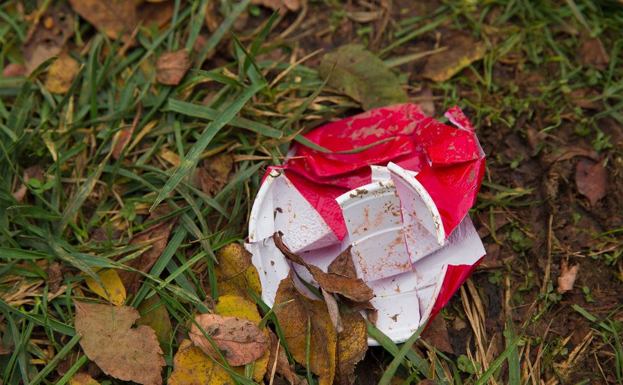 Ein zerbrochener Plastikbecher wird nach einer Party im Gras zurückgelassen. 