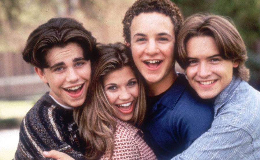 Strong, Fishel, Savage, and Friedle embrace in a group photo. 