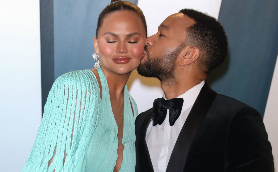 John Legend kisses Chrissy on the cheek.
