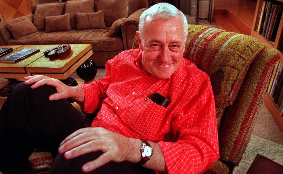 A picture of John Mahoney flashing a smile on the set of Frasier.