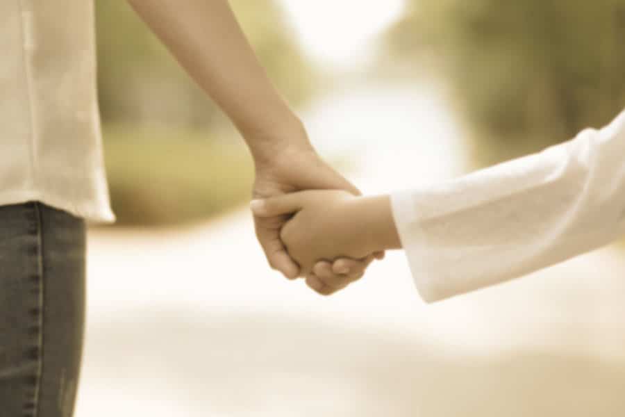 An image of a mother walking hand in hand with her daughter.