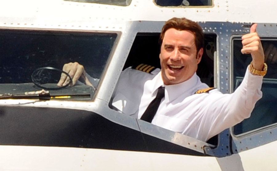 John Travolta waves to the crowd onboard on his jet.
