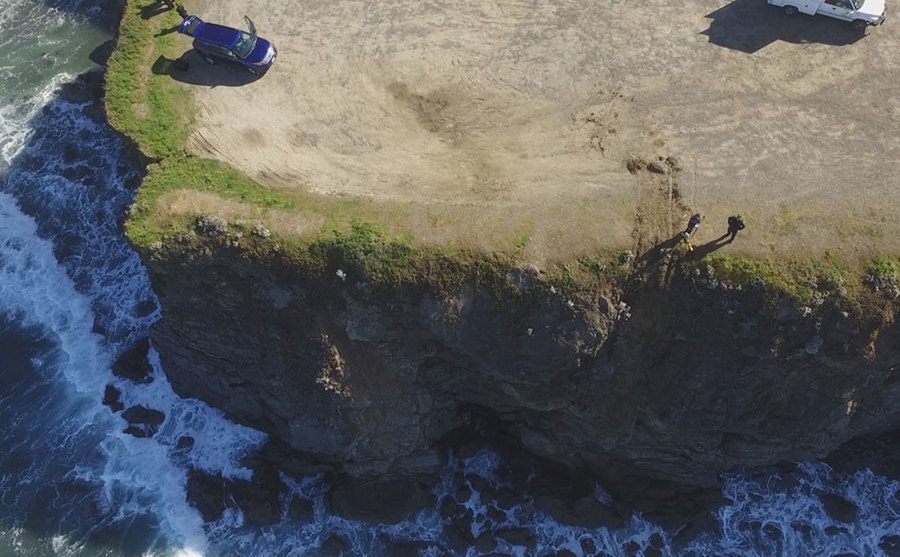 An aerial view of the scene after the car falls through the cliff. 