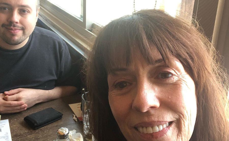 Mackenzie takes a picture with her son in a restaurant.