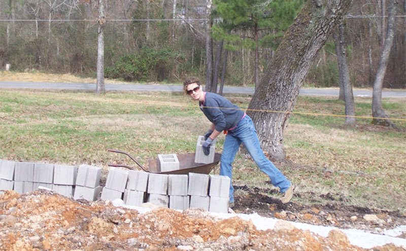 Cara is laying bricks. 