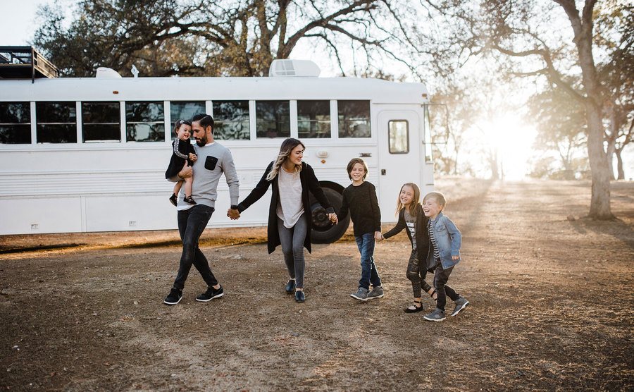 Debbie, Gabriel Mayes, and their kids take pictures outside the school bus. 
