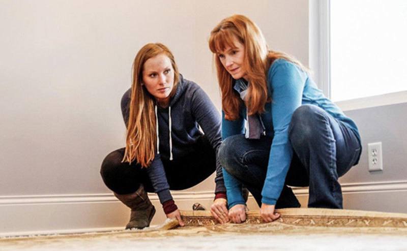 Mina and Karen rip out the rug in one of their renovations. 