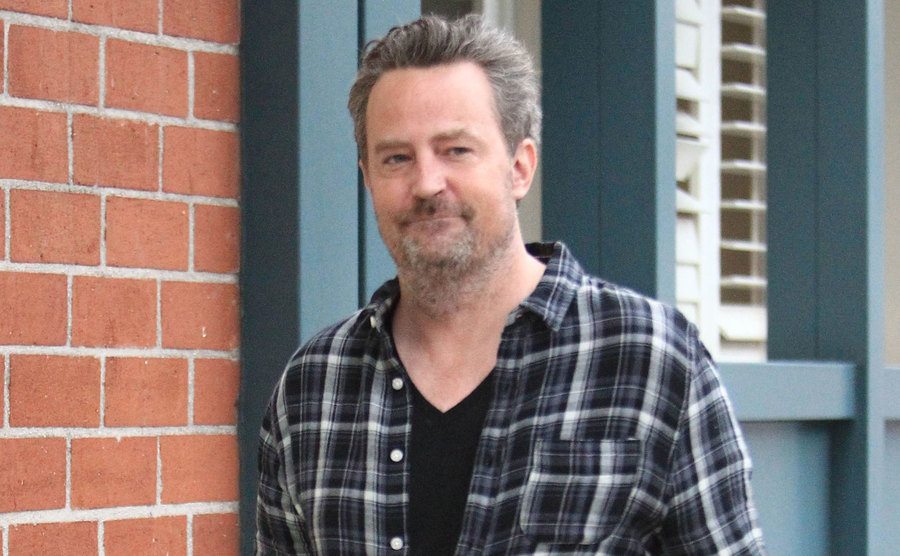 A photo of Matthew Perry walking the street.