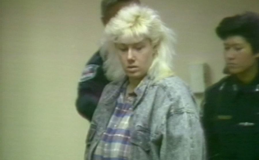 A dated video still of Cathy in court.