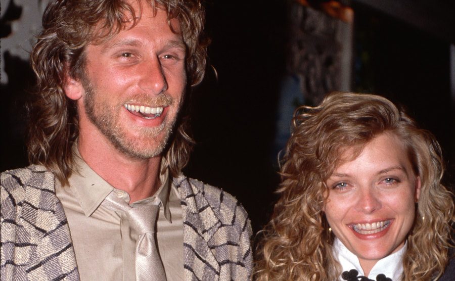 Michelle Pfeiffer and Peter Horton are smiling for the cameras at an event.
