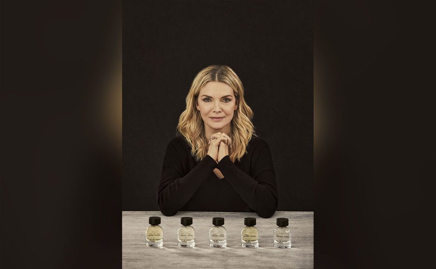 Pfeiffer poses with her perfume bottles. 