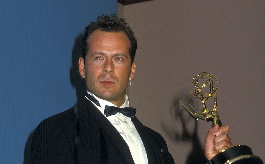 A photo of Bruce Willis posing backstage at the Emmys.