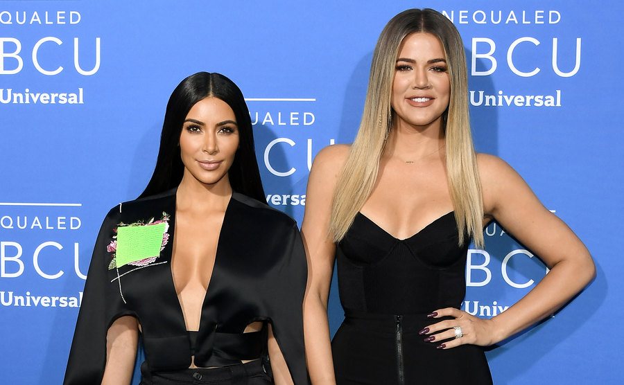 Kim Kardashian West and Khloe Kardashian attend an event. 