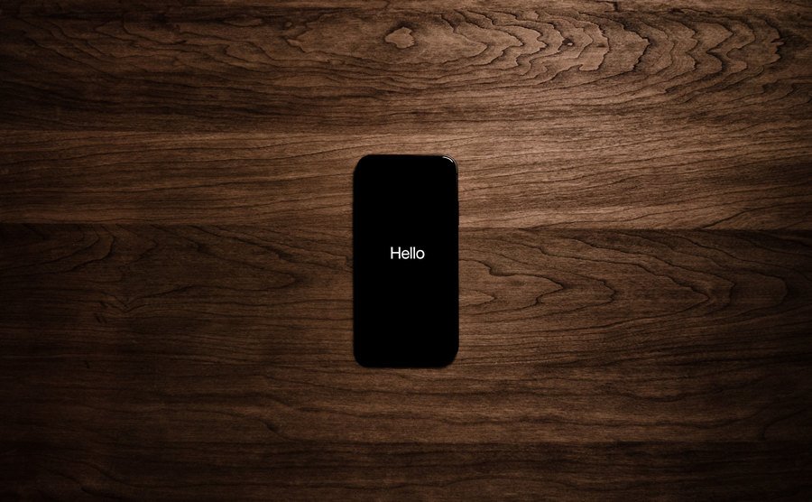 A photo of a phone on top of a wooden table.