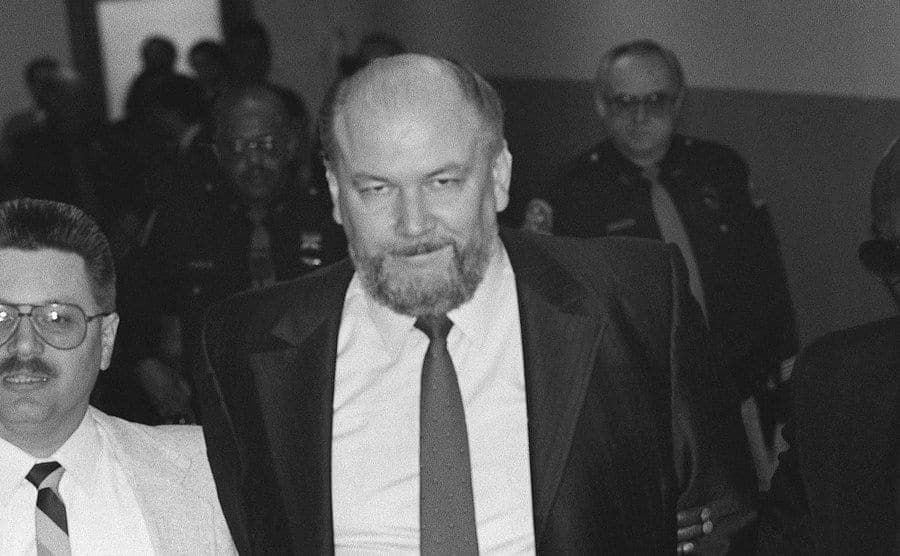A photo of Richard Kuklinski walking to the courtroom escorted by police.