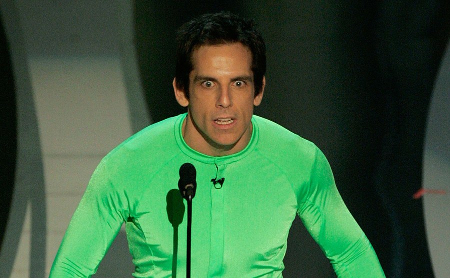 A photo of Ben Stiller wearing a costume as he speaks onstage.