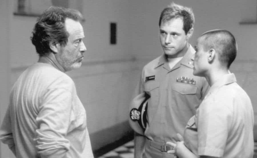 A photo of Demi Moore, Jason Beghe, and Ridley Scott behind the scenes.