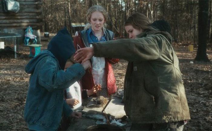 Lawrence skins a squirrel in a still from Winter’s Bone. 