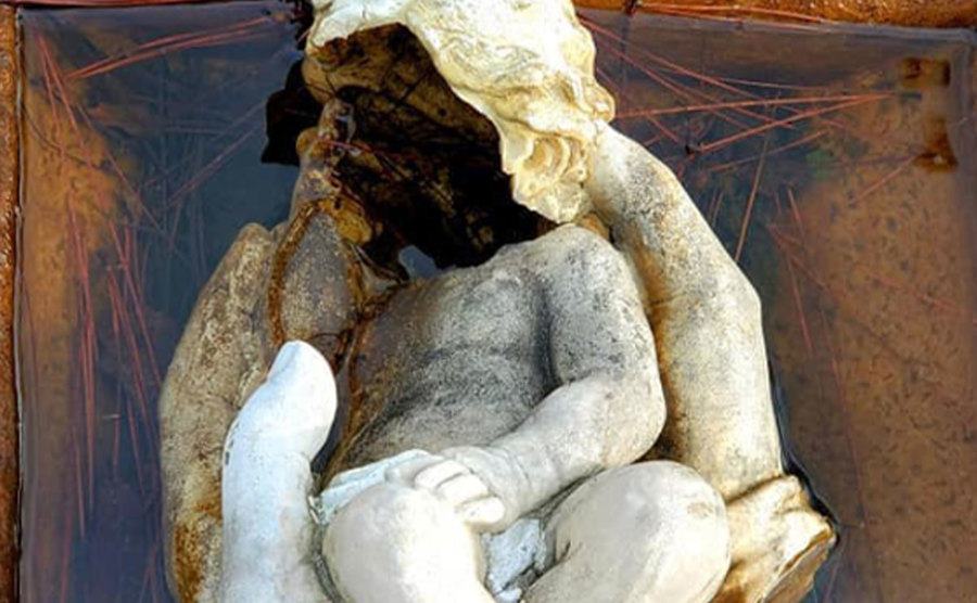 A wrecked sculpture of a hand holding a baby remains at the abandoned Bethesda Home.
