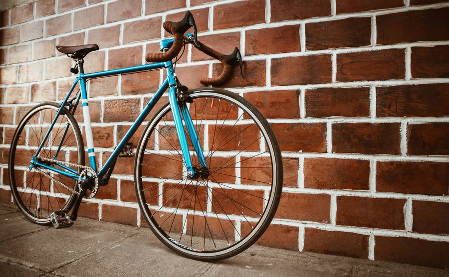 A picture of a bicycle next to a brick wall.