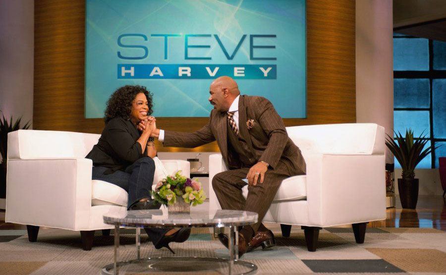 Steve Harvey hosts Oprah Winfrey on his talk show. 