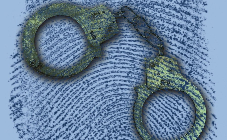 An image of handcuffs in a magnified fingerprint.
